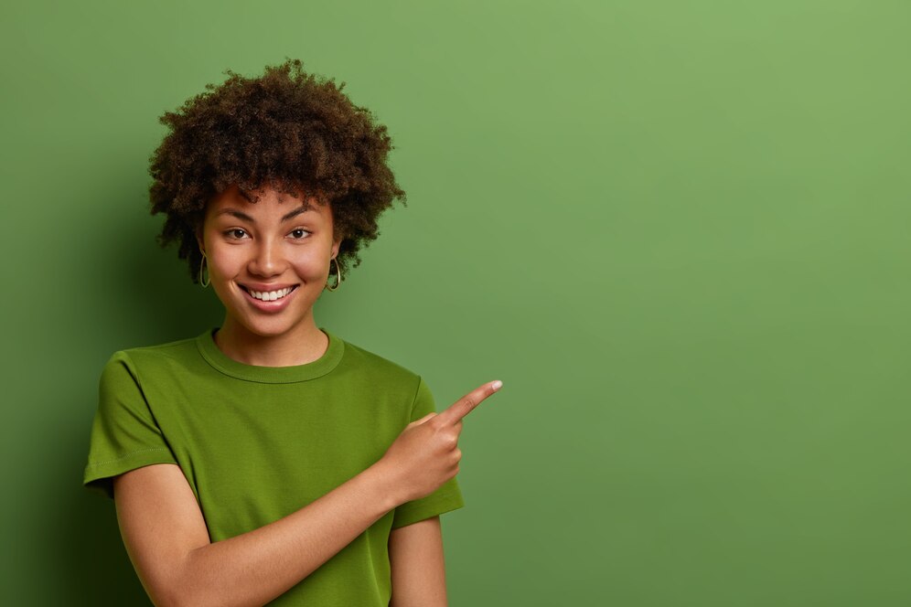 friendly-looking-glad-female-shop-assistant-happy-help-customers-shows-way-demonstrates-discounts-shop-points-fore-finger-aside-empty-space-green-wall-273609-39447.jpg